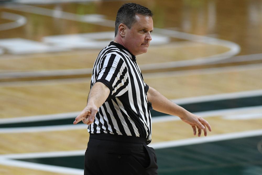 a basketball referee makes a call at a basketball game