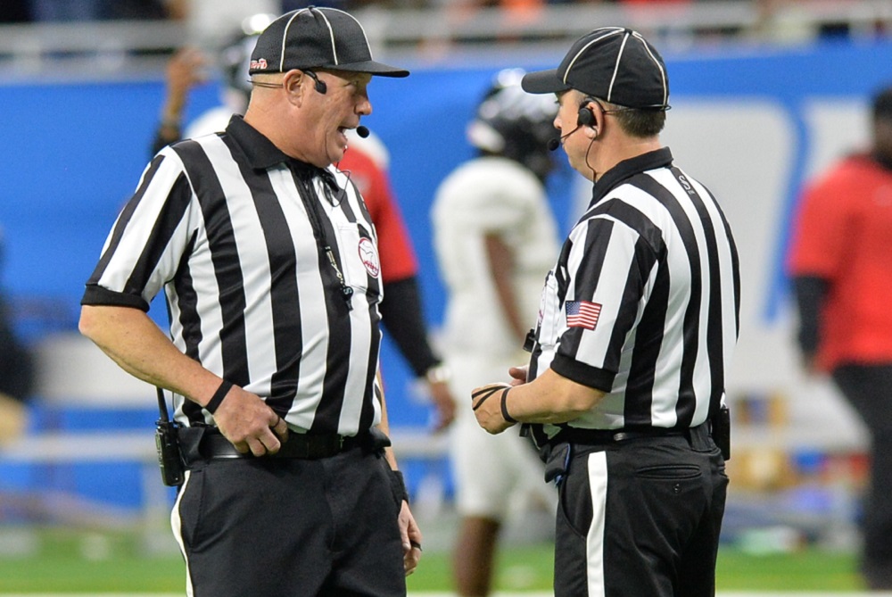 Referees have a brief discussion during the 2021 Finals at Ford Field.