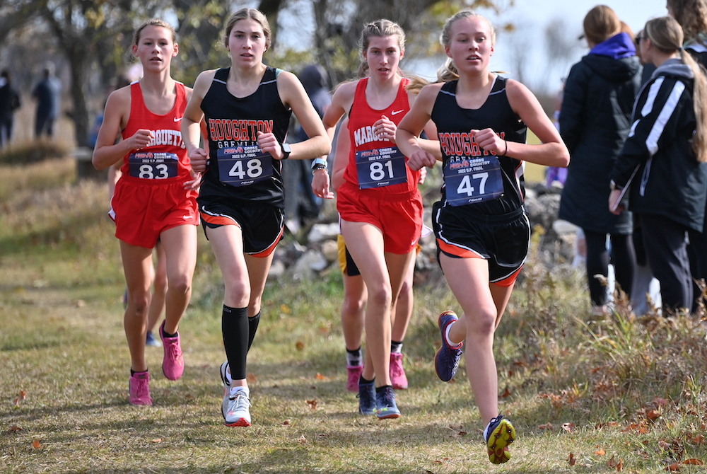 Houghton's freshman Tessa Rautiola (47) and sophomore teammate Lily Ross (48), and Marquette freshman Ella Fure (83) and sophomore Monet Argeropoulos (81) run together during the Division 1 race. 
