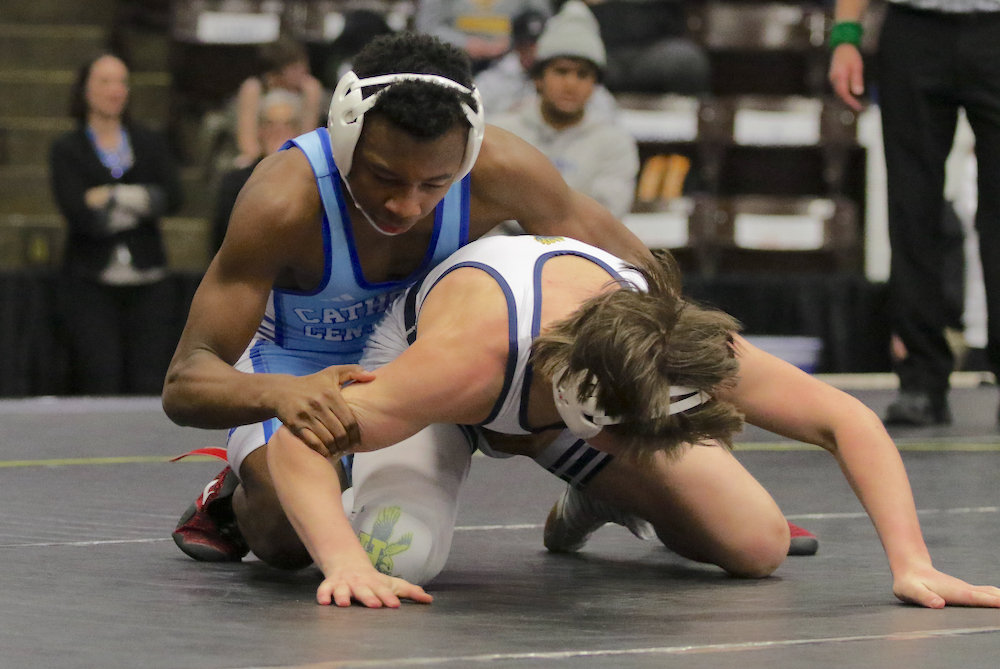 DCC’s Clayton Jones, top, locks up with Hartland’s Gavin Kern at 144 pounds.