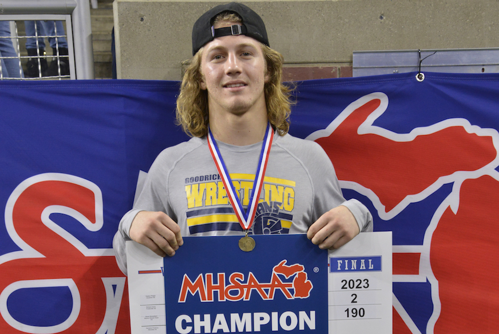 Goodrich’s Easton Phipps takes a champion’s photo at Ford Field.