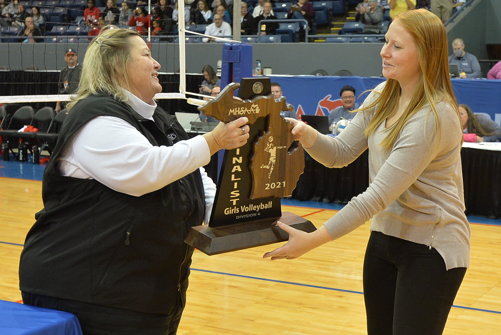 Karen Leinaar, left, awards the 2022 Division 4 volleyball finalist trophy to Indian River Inland Lakes coach Nicole Moore