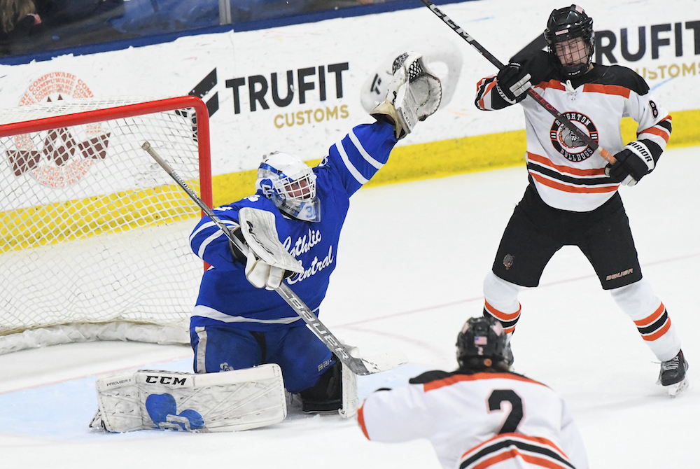 Detroit Catholic Central goalie Luca Naurato reaches high for a potential save during his team's 3-0 shutout of Brighton. 