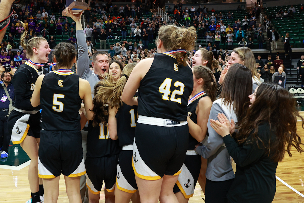 Maple City Glen Lake celebrates its Division 4 championship Saturday as coach Jason Bradford presents the trophy to his team.