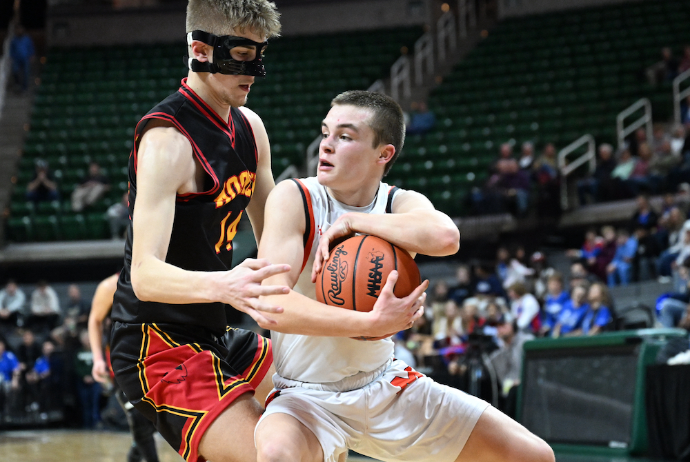 Munising’s Trevor Nolan (5) protects the ball while Cardinal Mooney’s Dominic Cattivera defends.