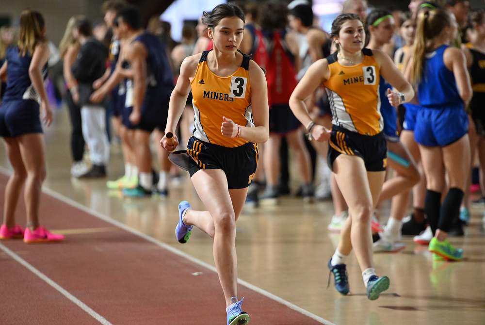 Negaunee's Nori Korsman gets the handoff from teammate Olivia Lunseth to run the third leg of the winning 1,600 relay at April's Superior Dome Invitational.