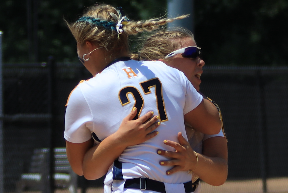 Hartland’s Kylie Swierkos (27) leaps into the arms of catcher Sadie Malik on Saturday.