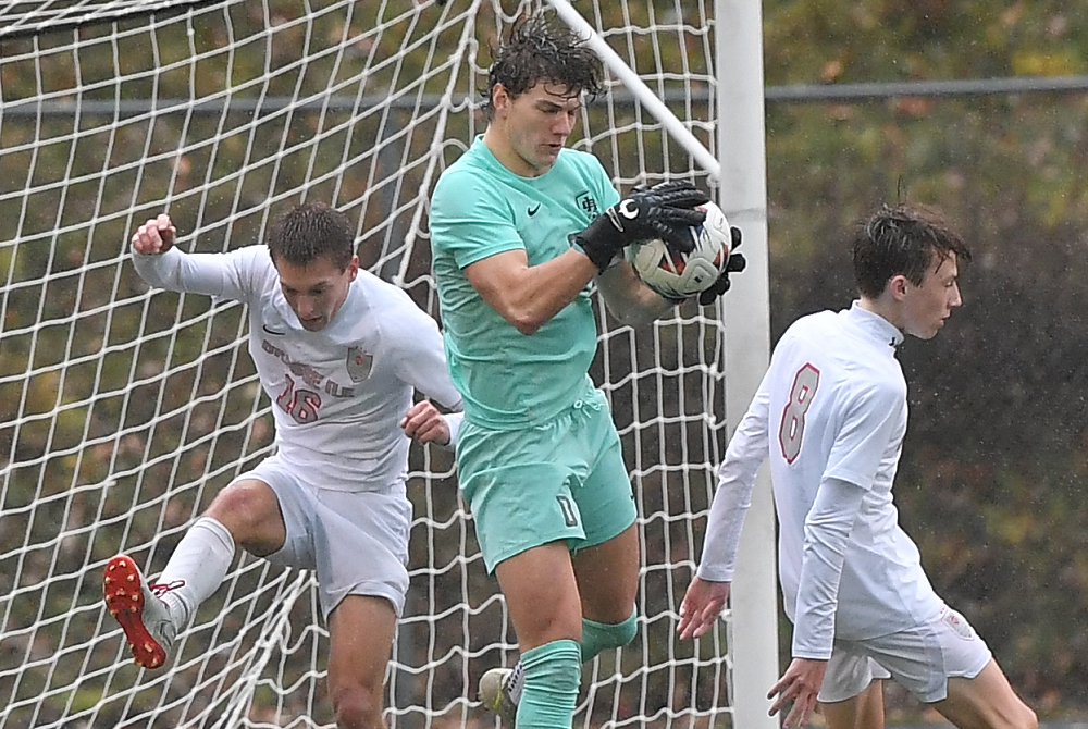 Holland Christian keeper Daniel Morgan, center, pulls in the ball in front of his net during his team’s Division 3 Final win over Grosse Ile.