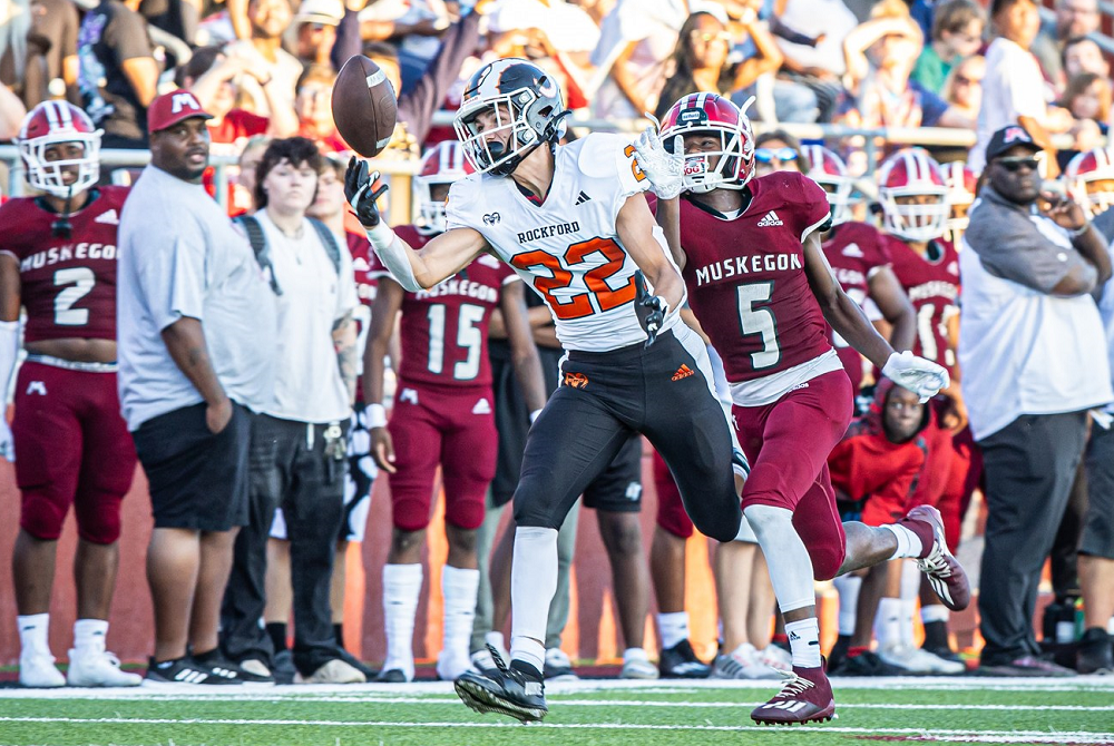 A Rockford received attempts to pull in a pass while covered closely during the Rams' opening-night win over Muskegon.