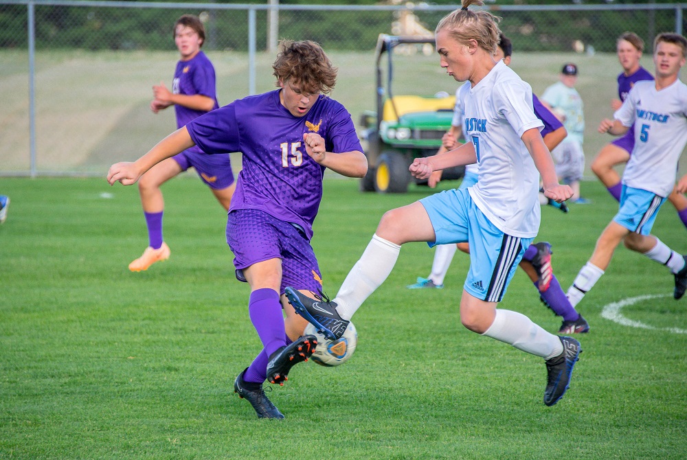 Schoolcraft’s varsity boys soccer team, including Nyan Wonders (15), faces Comstock this season on its field in the outfield of the baseball stadium.