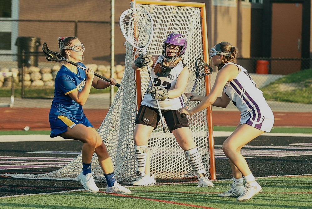 Bloomfield Hills goalie Sydney Butler, center, prepares for a shot at her net against Bloomfield Hills Marian on May 11.