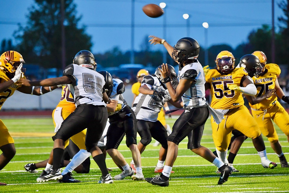  Davison applies a pass rush as Saginaw United takes to the air during the Cardinals' 63-0 win Friday. 