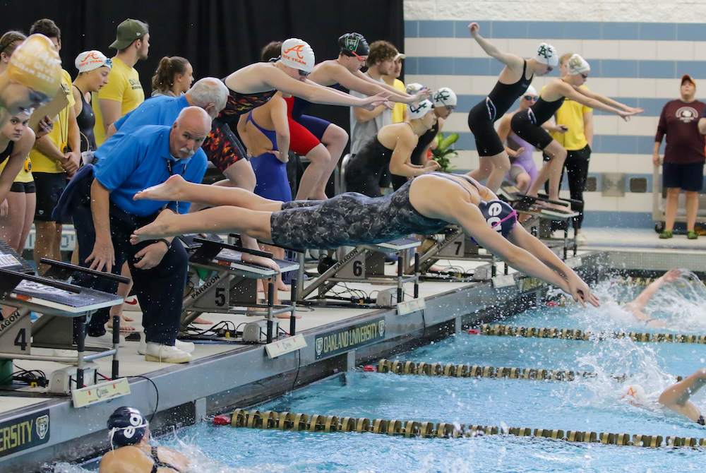 East Grand Rapids launches during a relay exchange Saturday at Holland Aquatic Center.