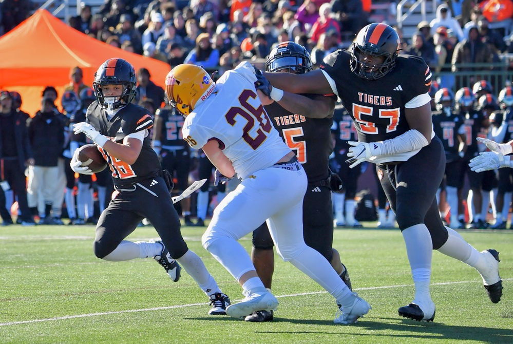 Belleville blockers including Damon Denny (57) create running room during Saturday's 63-21 Division 1 Semifinal win over Davison. 