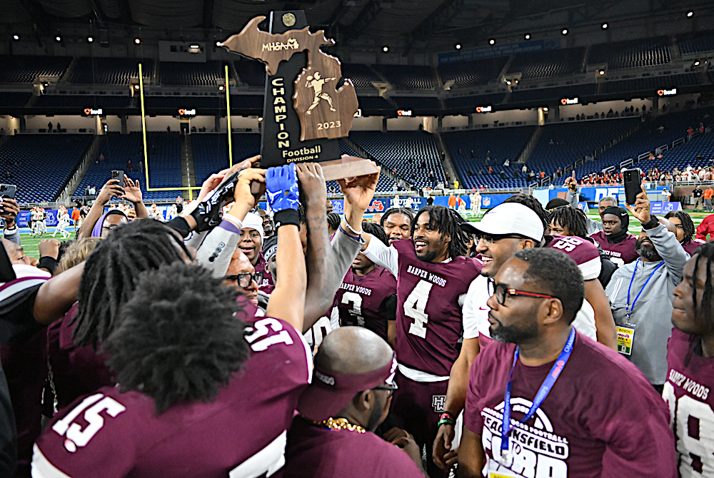 Harper Woods raises its first football championship trophy after winning the Division 4 Final on Saturday.