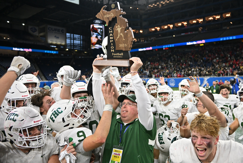 Forest Hills Central coach Tim Rogers holds up his program’s first championship trophy Sunday at Ford Field.