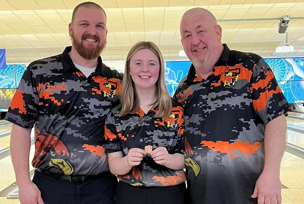 Flushing’s Hannah Reid shows off her Division 1 Final runner-up medal last season with coach Jeremy Jurvelin, left, and father and coach Mike Reid.