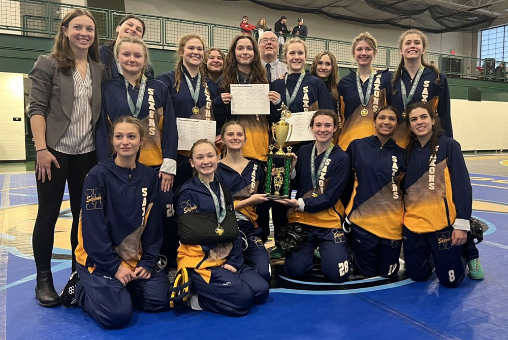 The Hastings girls wrestling team celebrates its team championship at the Grayling Invitational this season.