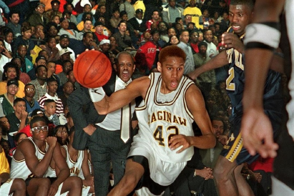 Saginaw Eugene Seals drives against Arthur Hill’s Jason Richardson – with coach Marshall Thomas in the background – during a sold-out 1999 game at the Saginaw Civic Center.