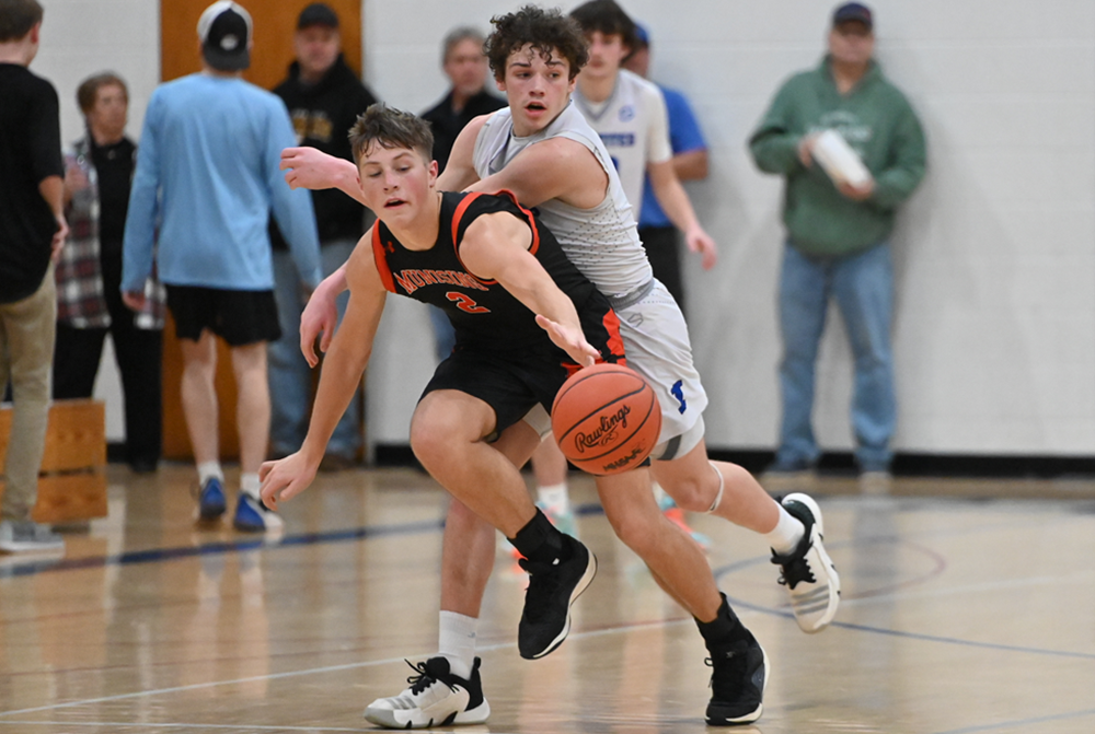 Munising's Carson Kienitz (2) and Ishpeming's Caden Luoma go after a loose ball during the Mustangs’ 54-48 win Dec. 28.