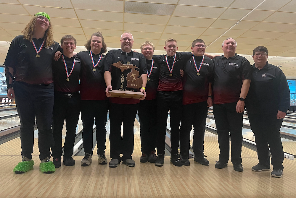 Traverse City Christian's boys hold up their championship trophy Friday.