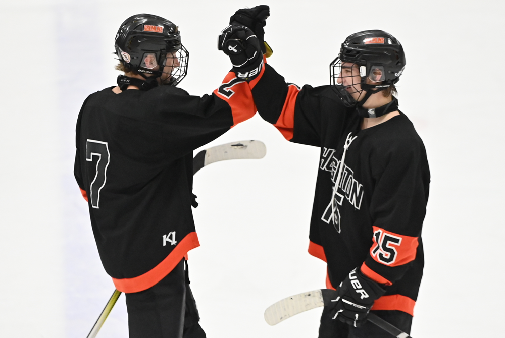 oughton's Wyatt Jenkins' (7) and Jace DeForge (15) celebrate winning the Great Lakes Hockey Conference title after playing Marquette to a 1-1 overtime tie on Feb. 16.