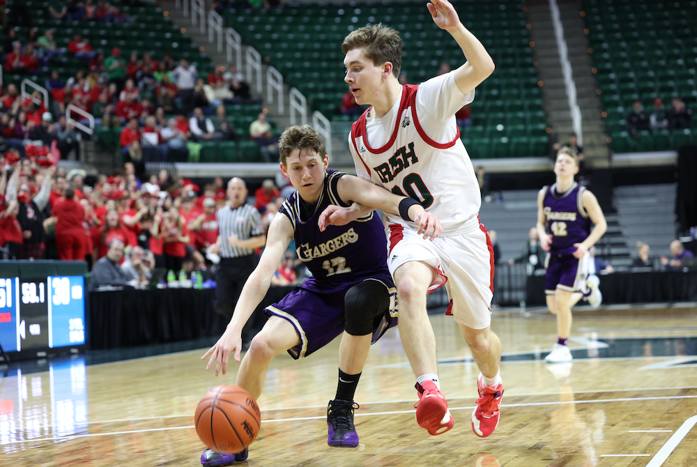 Sacred Heart’s Alex Latham (20) walls off Inter-City Baptist’s Luke Taylor during Thursday night’s Semifinal at Breslin Center. 