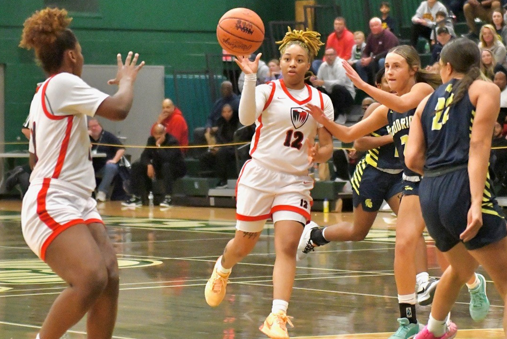 Detroit Edison's Na'kiya Bonner (12) passes to teammate Devin Hagemann during Tuesday's Quarterfinal win over Goodrich. 