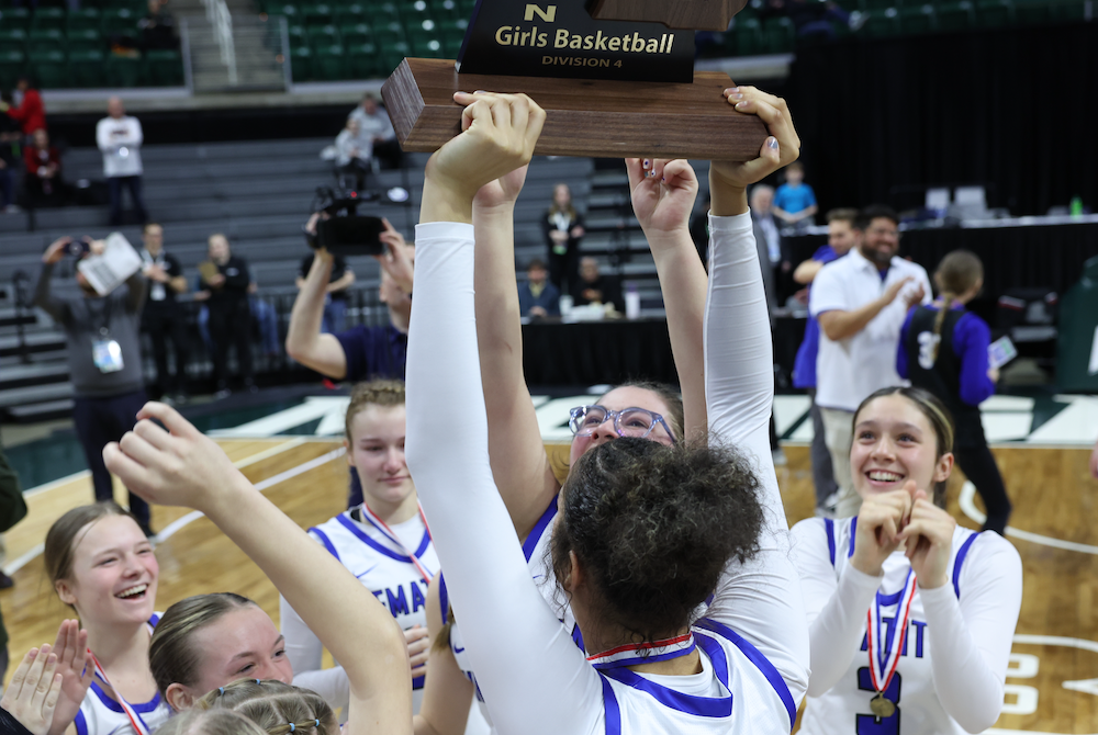 Ishpeming players raise their championship trophy Saturday at Breslin Center.
