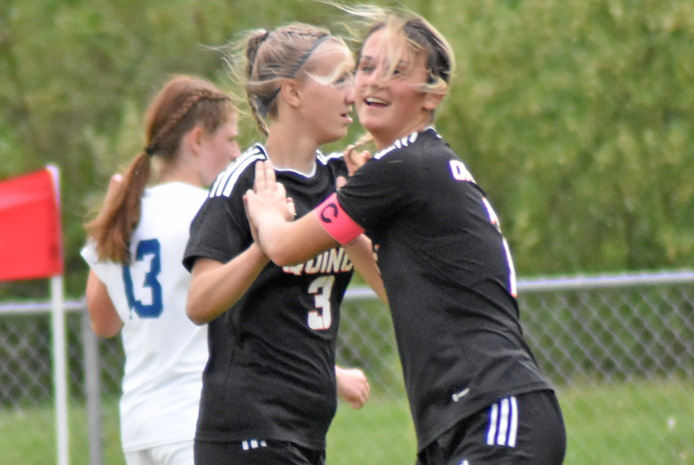 Quincy senior striker Sami Hollenbaugh, far right, celebrates with a teammate after scoring this season.