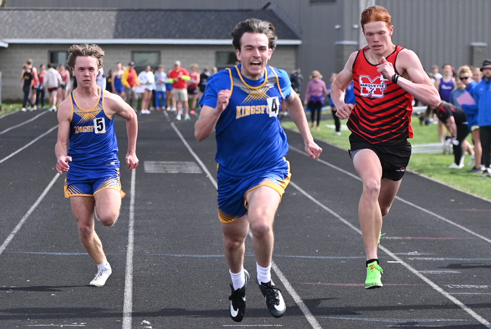 Kingsford's Michael Floriano, center, edges Marquette's Jacob MacPhee in the 100 dash May 10 in Negaunee. 