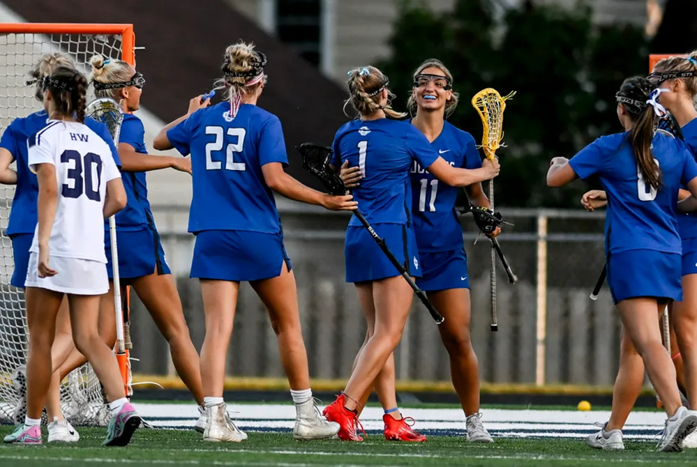 Grand Rapids Catholic Central’s Sarah Rott (11) and Cate Marshall (1) celebrate Marshall’s goal during the first quarter of Wednesday’s Semifinal against Haslett/Williamston.