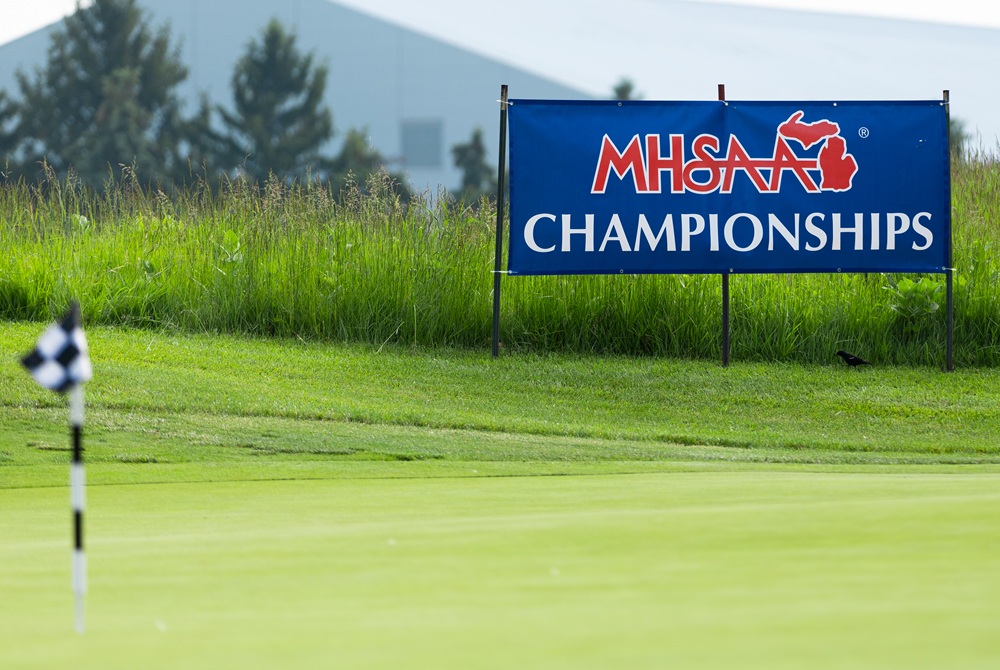 This is a photo of a putting green and an MHSAA championship banner.