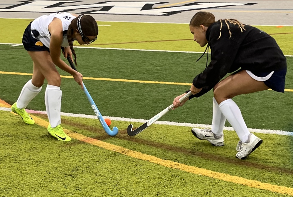 Clarkston field hockey players Juliet Hardin (left) and Zoe Philbrick battle for a ball during warmups before a game Wednesday against West Bloomfield.