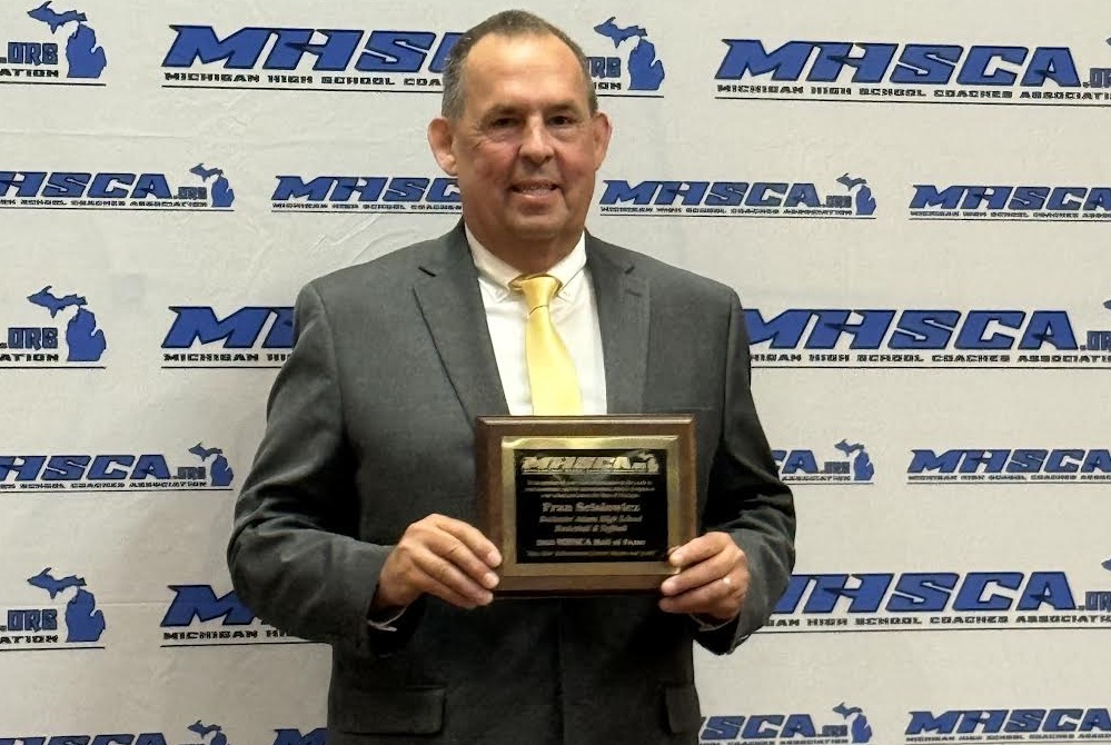 Fran Scislowicz holds up his plaque after his induction into the MHSCA Hall of Fame.