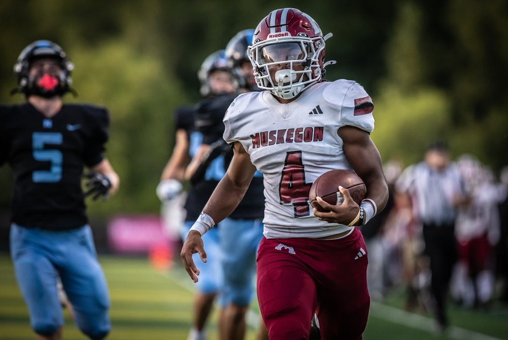 A Muskegon ball carrier pulls away from Grand Rapids Forest Hills Northern's pursuing defenders during the Big Reds' 40-21 win last week.