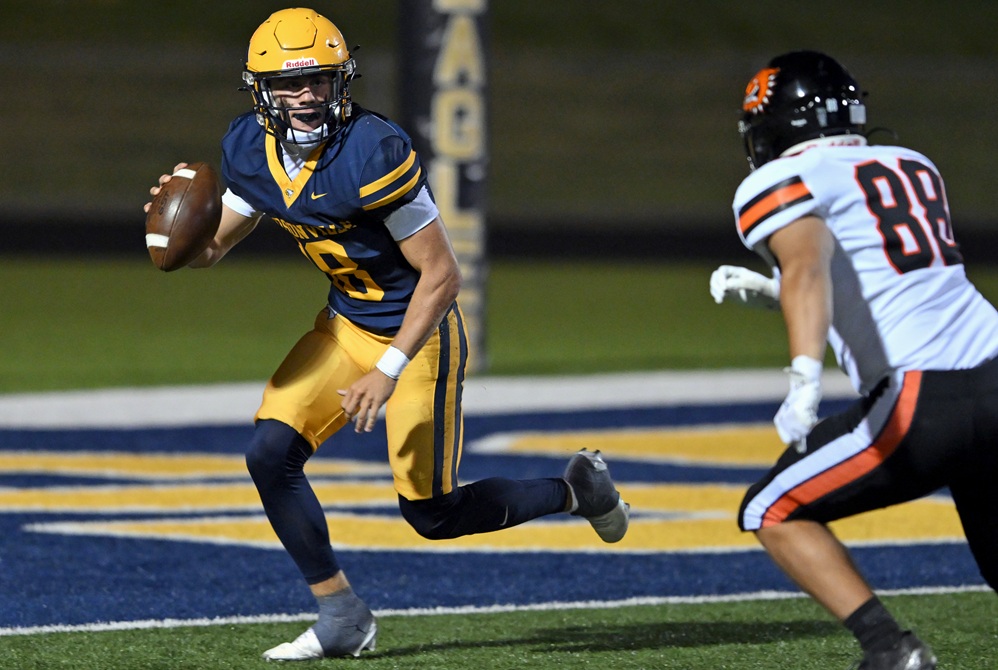 Hudsonville quarterback Brady Van Laecke considers his options while a Byron Center defender pursues.