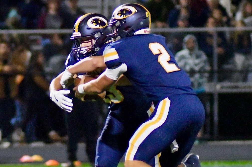 DeWitt’s backs make a read on a handoff during their team’s 59-7 win over Grand Ledge on Friday. 
