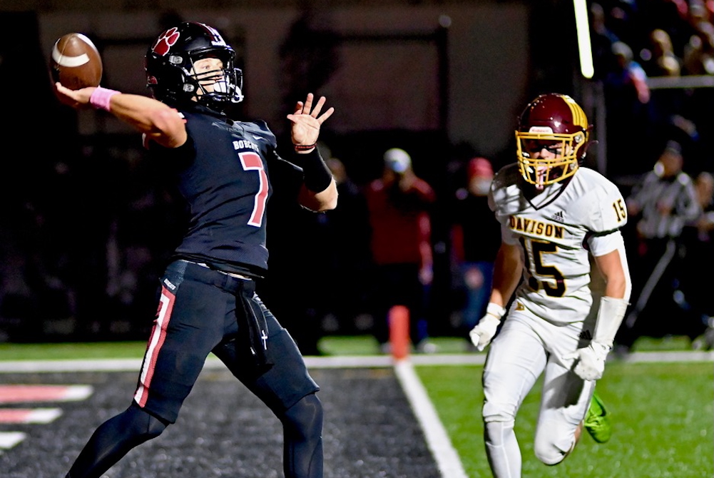Grand Blanc quarterback Jake Morrow throws a pass Friday with a Davison rusher in pursuit.