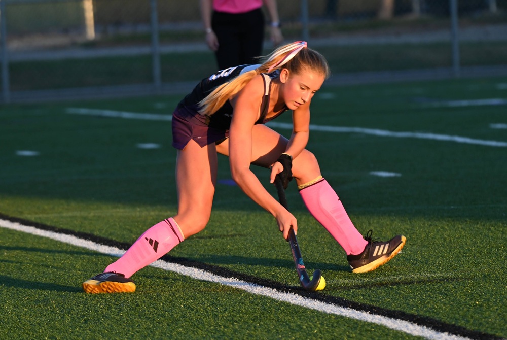 A field hockey player connects on a stroke. 