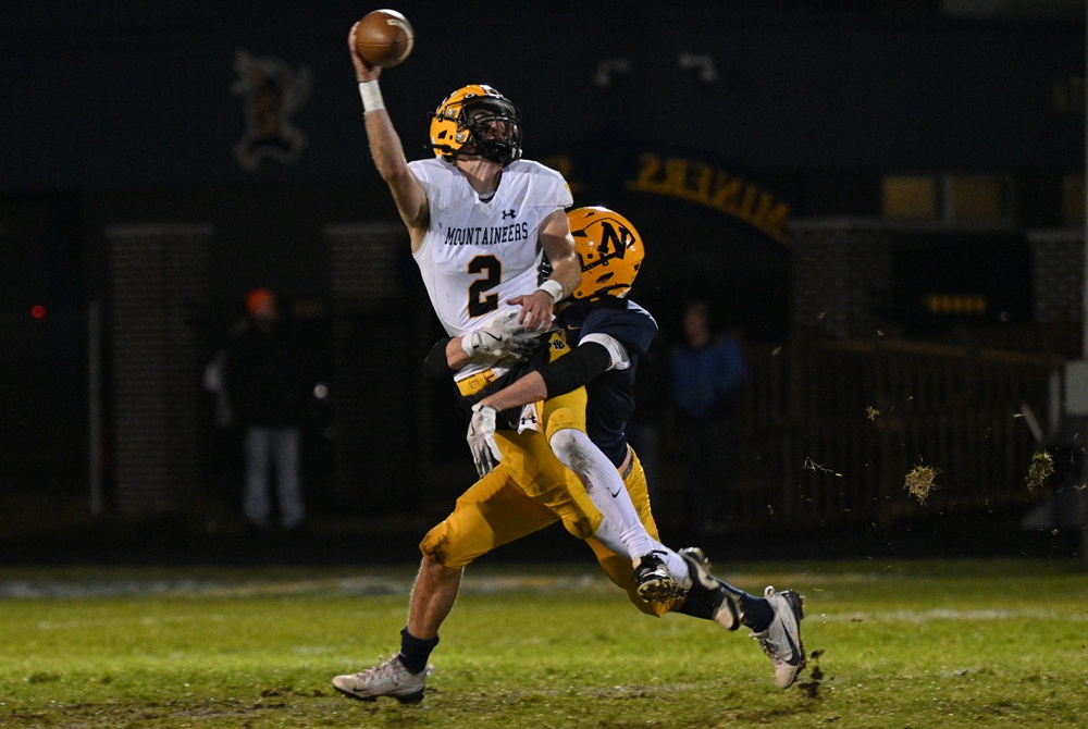 Negaunee's David Juchemich is able to get to Iron Mountain's quarterback Brayden Kassin.