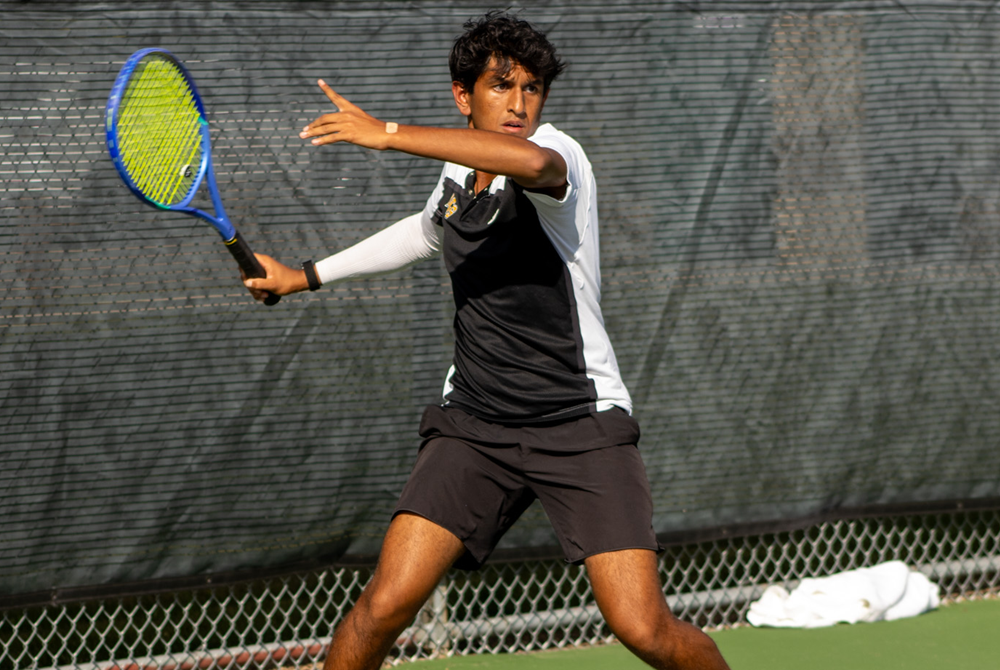 Stephen Gollapalli prepares to hit a forehand during a tennis match.