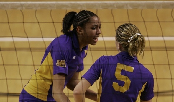 Alisha Glass talks with a Leland teammate near the volleyball net.