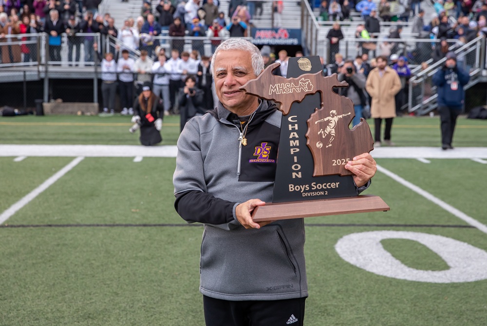 De La Salle boys soccer coach Thaier Mukhtar holds up his team’s championship trophy after the Pilots clinched the Division 2 title Nov. 1 at Grand Ledge High School. 
