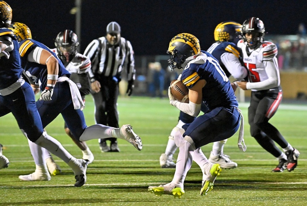 Clarkston's Griffin Boman (0) follows his blockers as a Grand Blanc defender pursues during the Wolves' District Final win Friday.