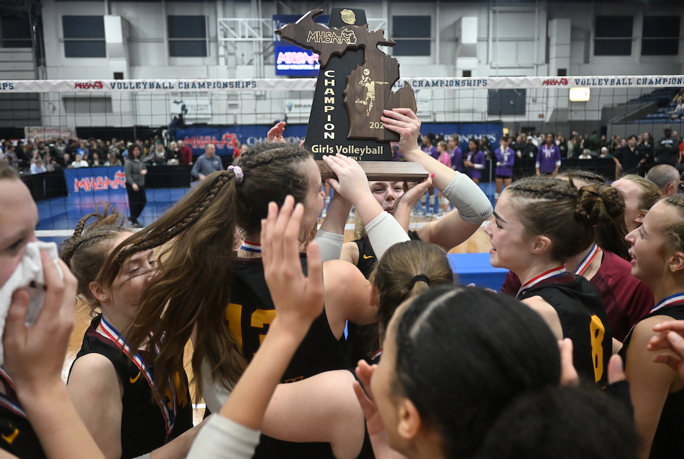 Farmington Hills Mercy players raise their championship trophy Saturday afternoon at Kellogg Arena.