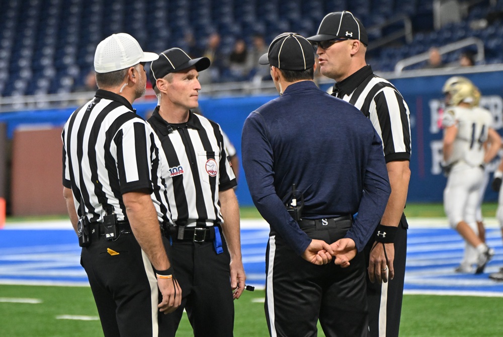Football officials discuss a play during review. 