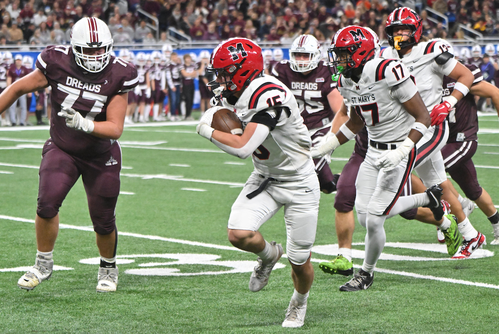 Orchard Lake St. Mary’s Daniel Taylor Jr. (15) sprints down the sideline as Dexter’s Grant Davis (77) and others chase him Friday. 