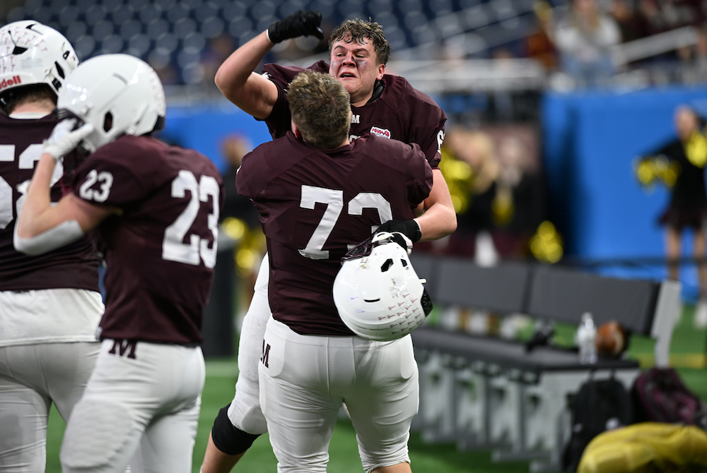 Menominee’s Brayden Daigneau (73) hoists a teammate into the air Sunday as they celebrate their team’s Division 7 title. 