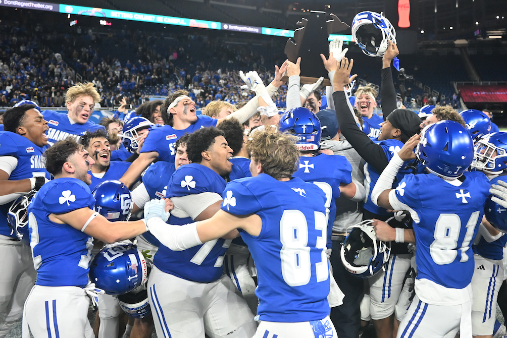 Detroit Catholic Central players celebrate Sunday while hoisting their championship trophy.